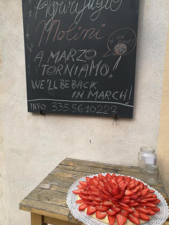 a table with a sign and a plate of fruit on it at Agririfugio Molini in Camogli