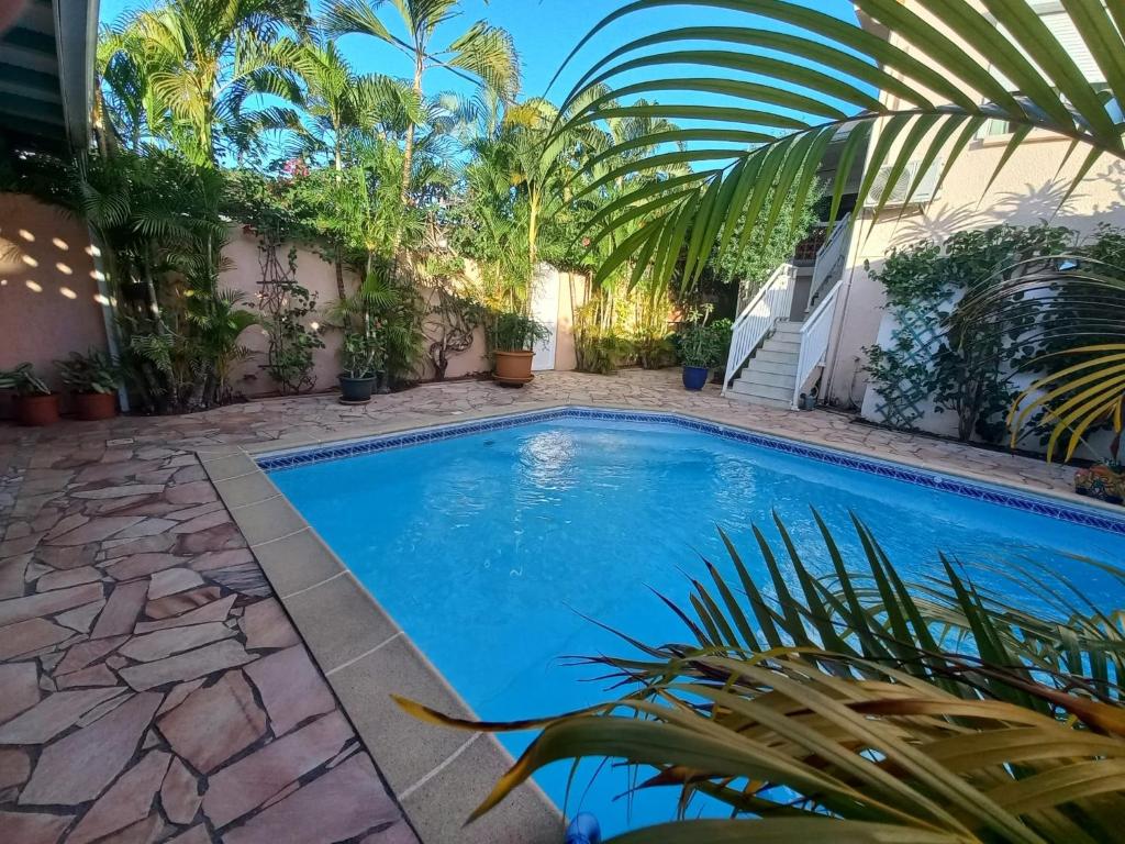a swimming pool in a courtyard with plants at Villa Les Oursins 130 m² - Piscine privée in Les Trois-Îlets
