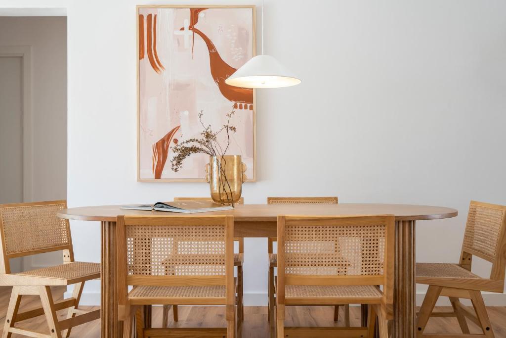 a dining room table with chairs and a bird on the wall at Villa Tropico - Design house with pool in Corralejo in Corralejo
