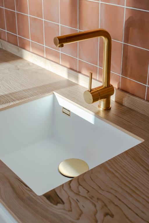 a sink in a bathroom with a gold faucet at Villa Tropico - Design house with pool in Corralejo in Corralejo