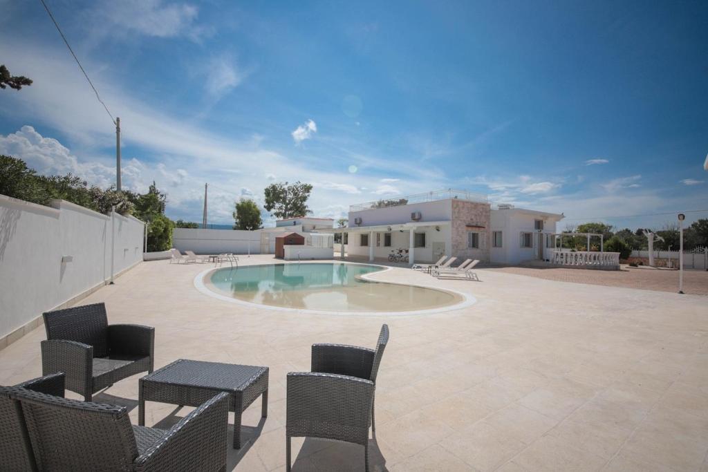 a patio with a pool and chairs and a house at Villa Ginevra la Dimora by Apulia Hospitality in Capitolo