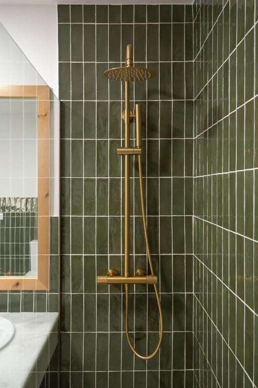 a shower in a bathroom with green tiled walls at Villa Tropico - Design house with pool in Corralejo in Corralejo