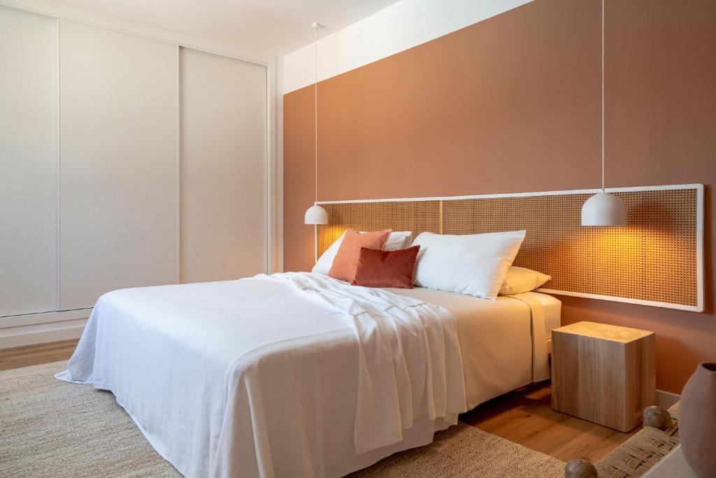 a bedroom with a large bed with white sheets at Villa Tropico - Design house with pool in Corralejo in Corralejo