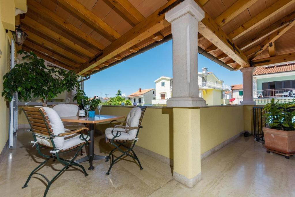 a patio with a table and chairs on a balcony at Guesthouse Casa Nova in Poreč