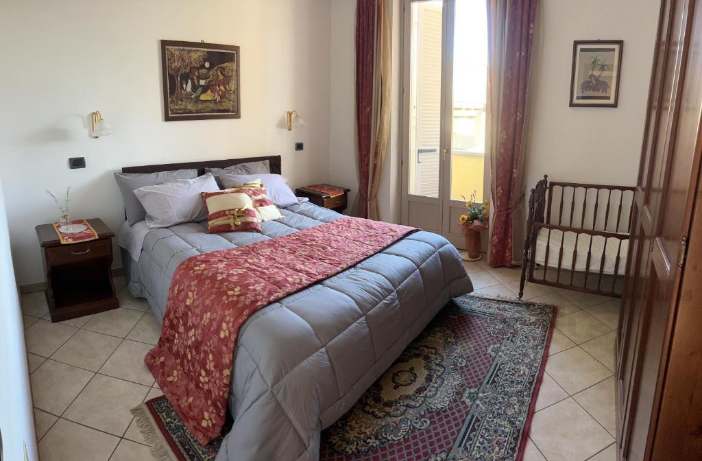 a bedroom with a large bed with a red blanket at CASA FRUSCIONE in Magliano Alfieri