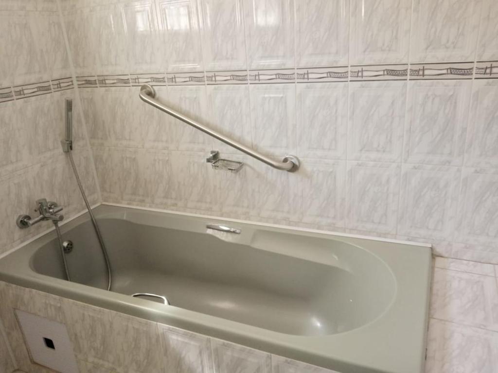 a bath tub in a bathroom with a towel rail at Casa MaSa Inn in Francistown