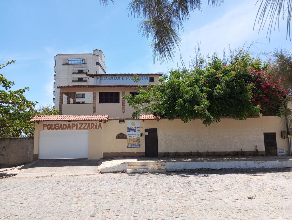 un bâtiment avec un panneau devant lui dans l'établissement Pousada e Pizzaria Sol e Alegria, à Fortaleza