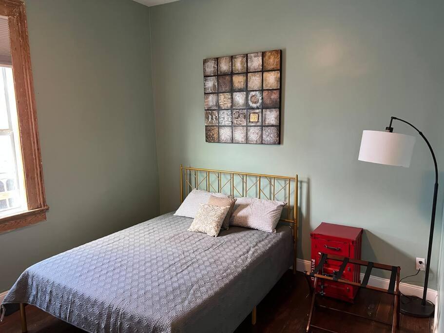 a bedroom with a bed and a painting on the wall at Chilled Pad 2 Blocks from the French Quarters in New Orleans