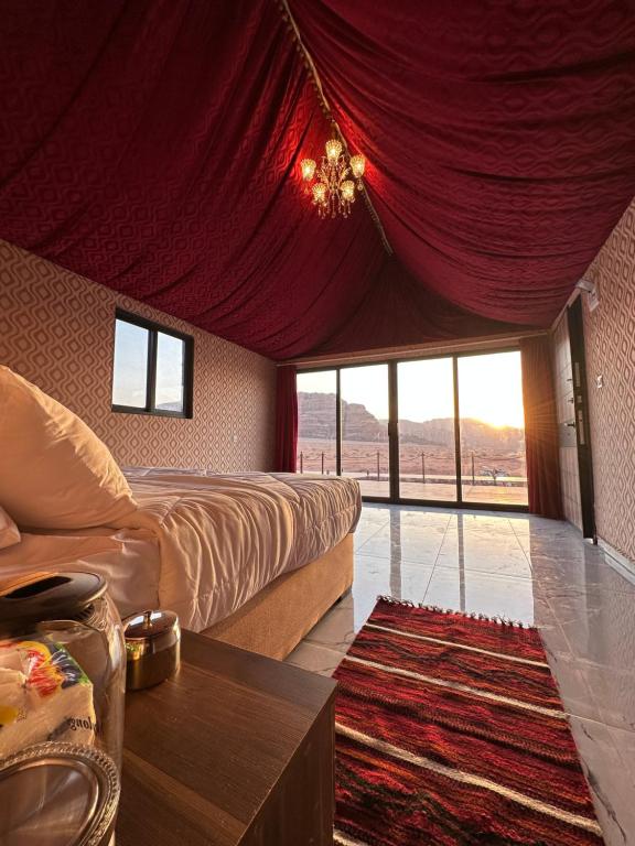 um quarto com uma cama e uma cortina vermelha em Wadi Rum Golden Valley em Wadi Rum