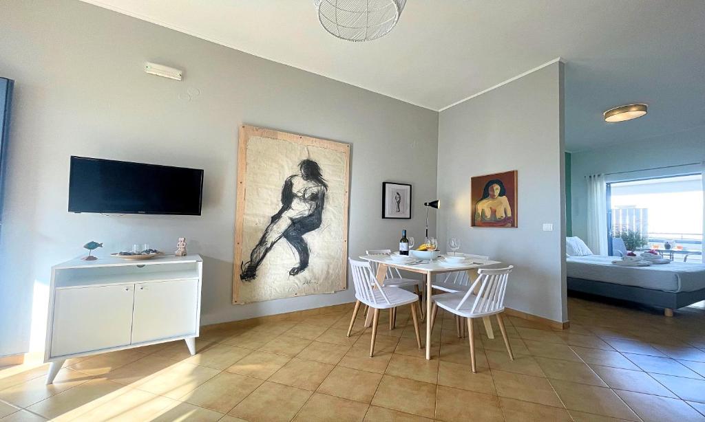 salon ze stołem i telewizorem na ścianie w obiekcie Art Apartment w mieście Palaiochóra