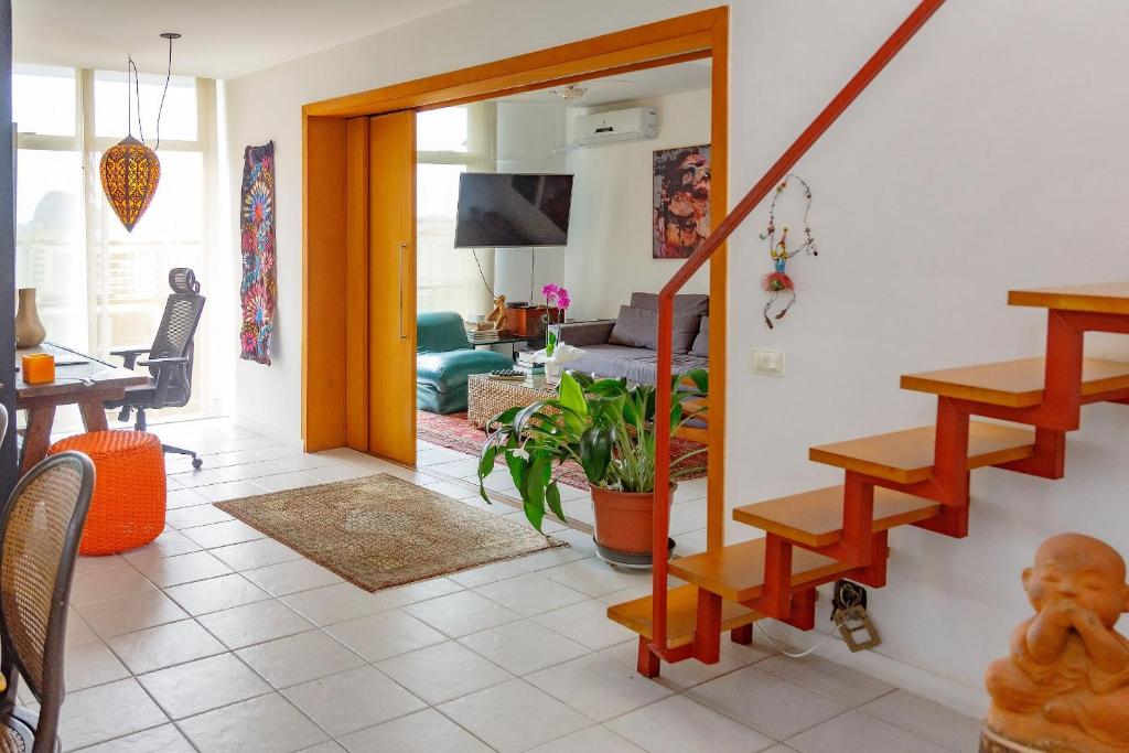 a living room with a staircase and a living room at Cobertura duplex com vista panoramica na Gavea in Rio de Janeiro