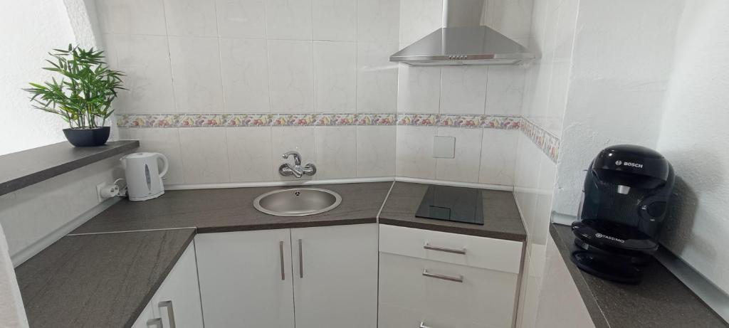 mała biała kuchnia ze zlewem i telefonem w obiekcie Estudio-La Colina-Torremolinos-Playa w mieście Torremolinos