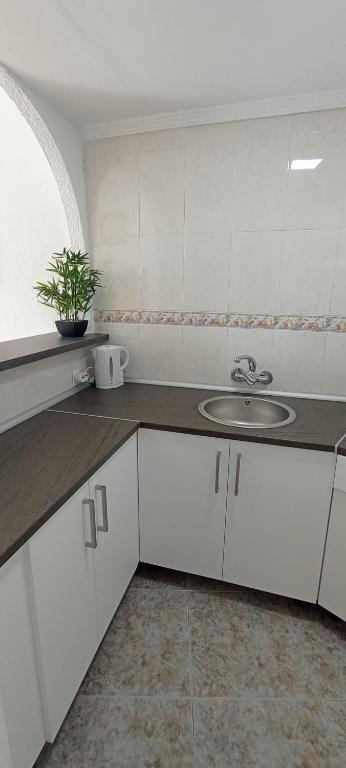 kuchnia z białymi szafkami i zlewem w obiekcie Estudio-La Colina-Torremolinos-Playa w mieście Torremolinos