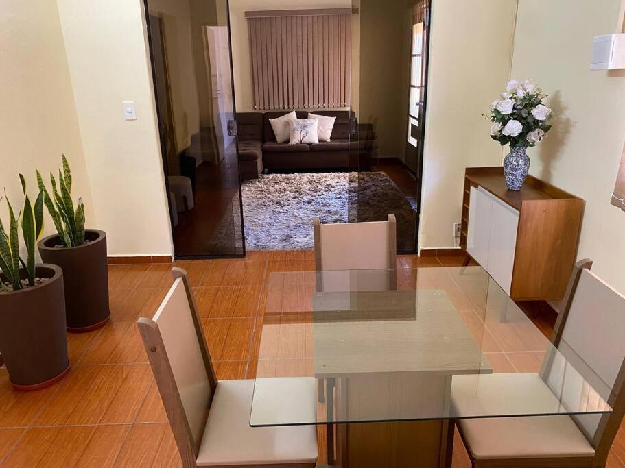 a living room with a glass table and a couch at Hospedaria Spring in Alfenas