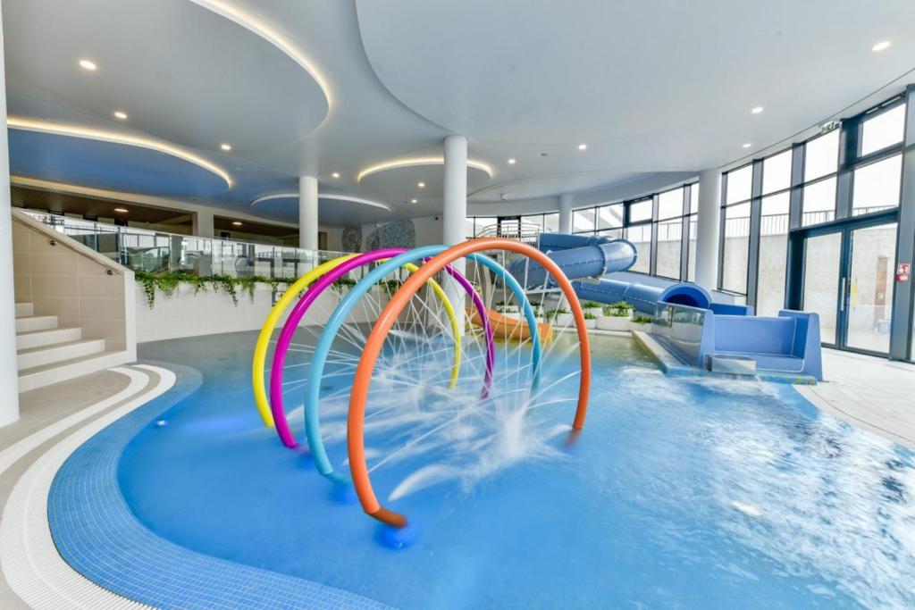 una piscina con un tobogán de agua en un edificio en Polanki Aqua Apartament FLORA en Kołobrzeg