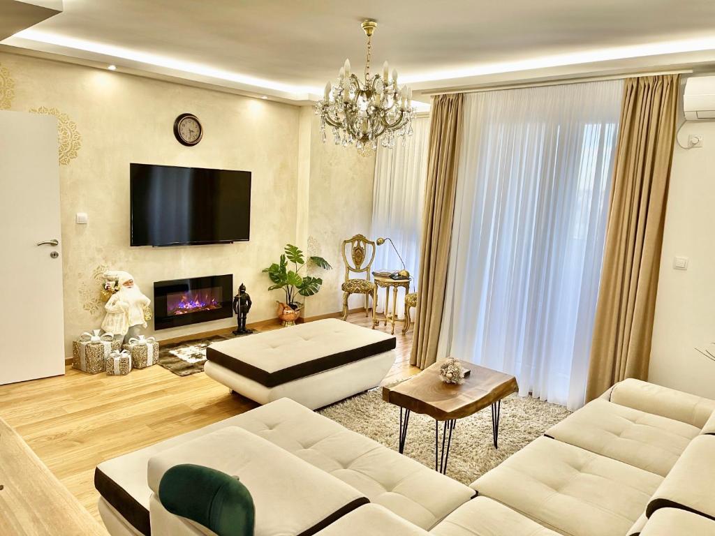 a living room with a couch and a tv at Plaza extra lux apartman garage free in Stanovo