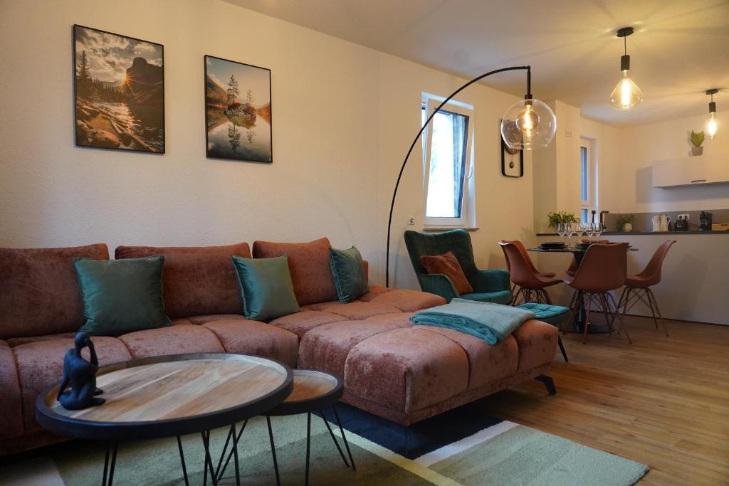 een woonkamer met een bank en een tafel bij Design-Apartment I Boxspring I Nespresso I Parkplatz in Bad Krozingen