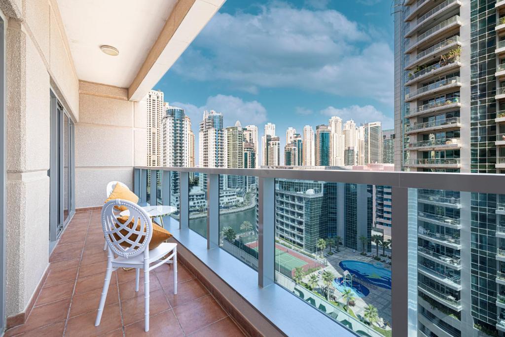 a balcony with a chair and a view of a city at Luxury and spacious full Marina view in Dubai