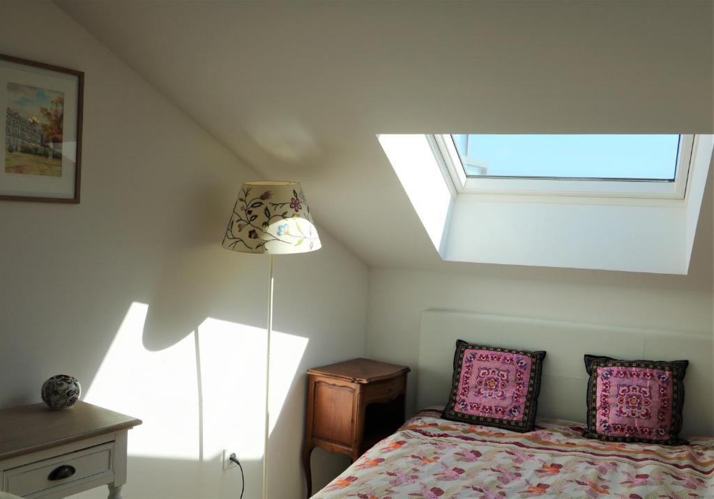 a bedroom with a bed with pink pillows and a window at Lovely flat close Paris Disney. in Neuilly-sur-Marne