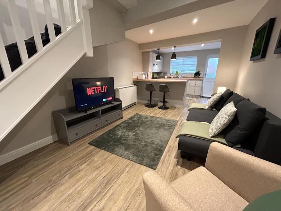 a living room with a couch and a tv at Brand New Cosy 1 Bedroom Home in Nantwich