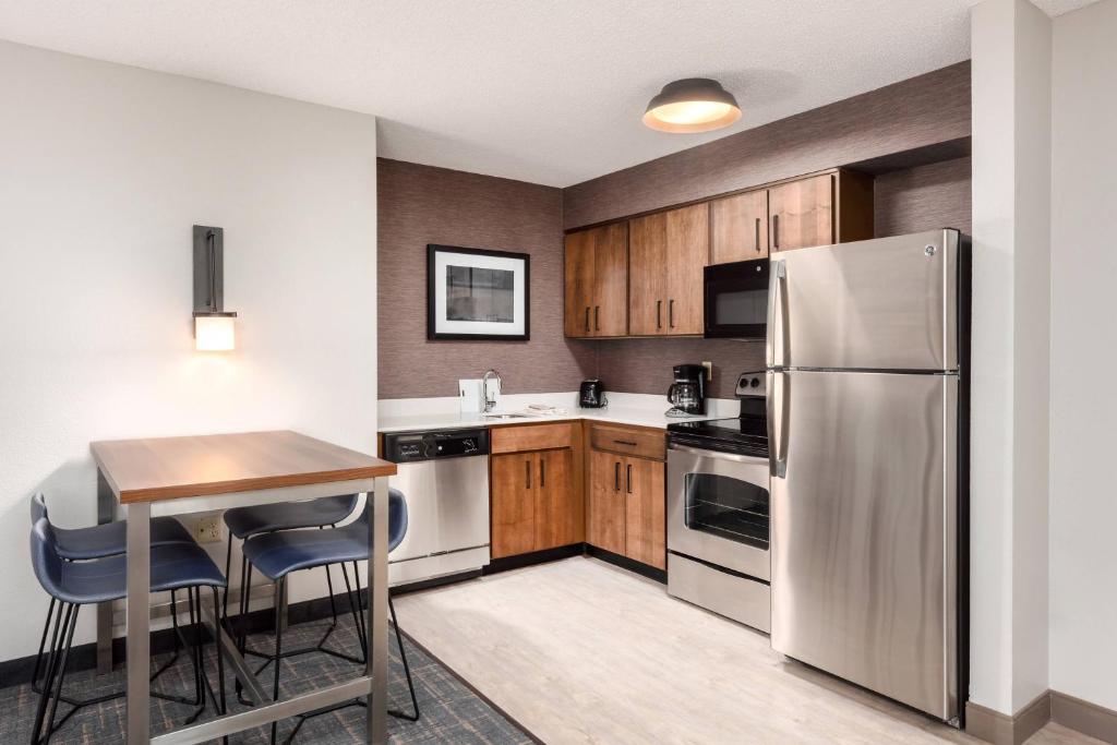 a kitchen with wooden cabinets and a stainless steel refrigerator at Residence Inn Springfield in Springfield