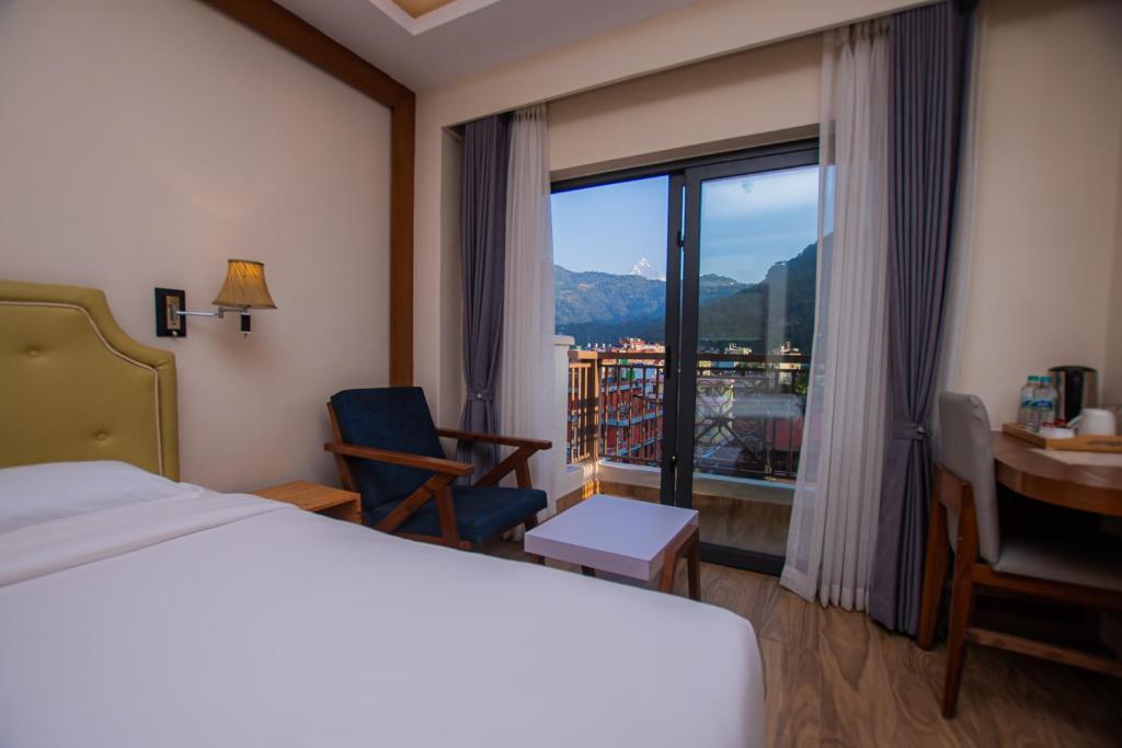a hotel room with a bed and a desk and a window at Hotel Fewa Trip in Pokhara
