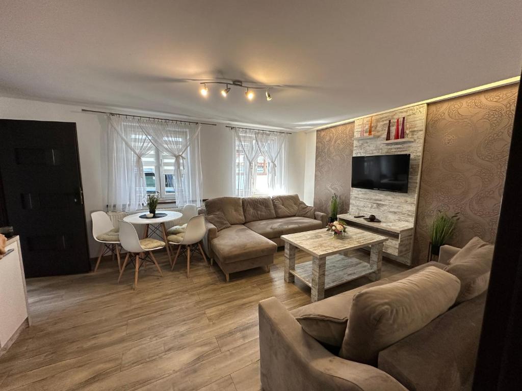 a living room with a couch and a table at Apartamenty Ostryga Łeba in Łeba