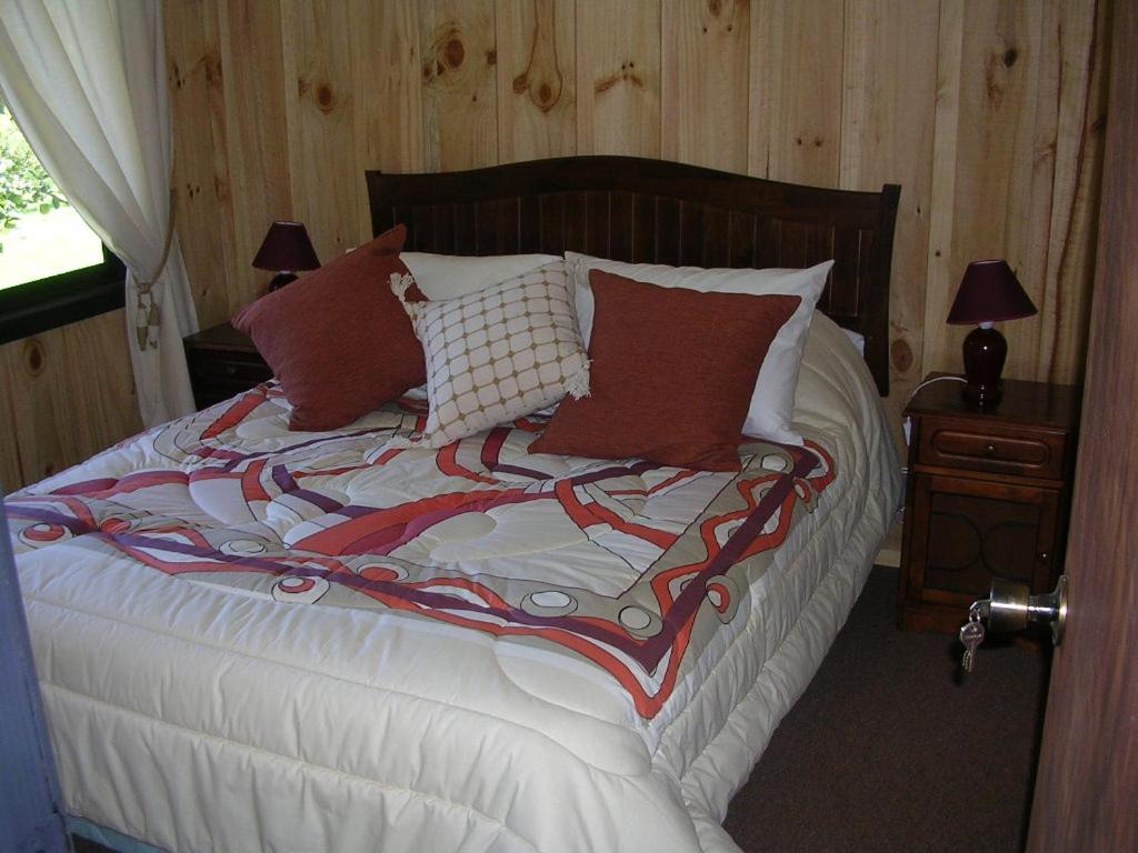 a bedroom with a bed with white sheets and red pillows at A&O Courmayeur in Courmayeur