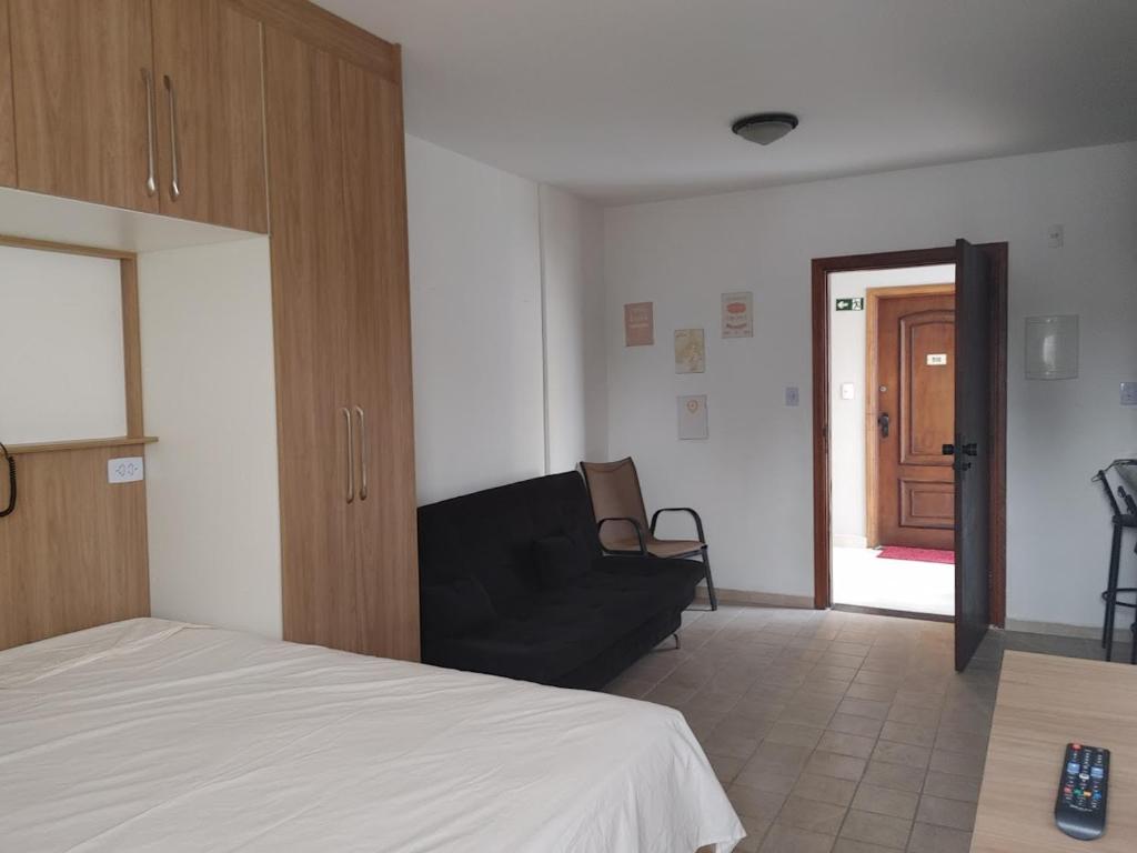 1 dormitorio con 1 cama y 1 sofá en una habitación en Flat Palladium super aconchegante en São Vicente
