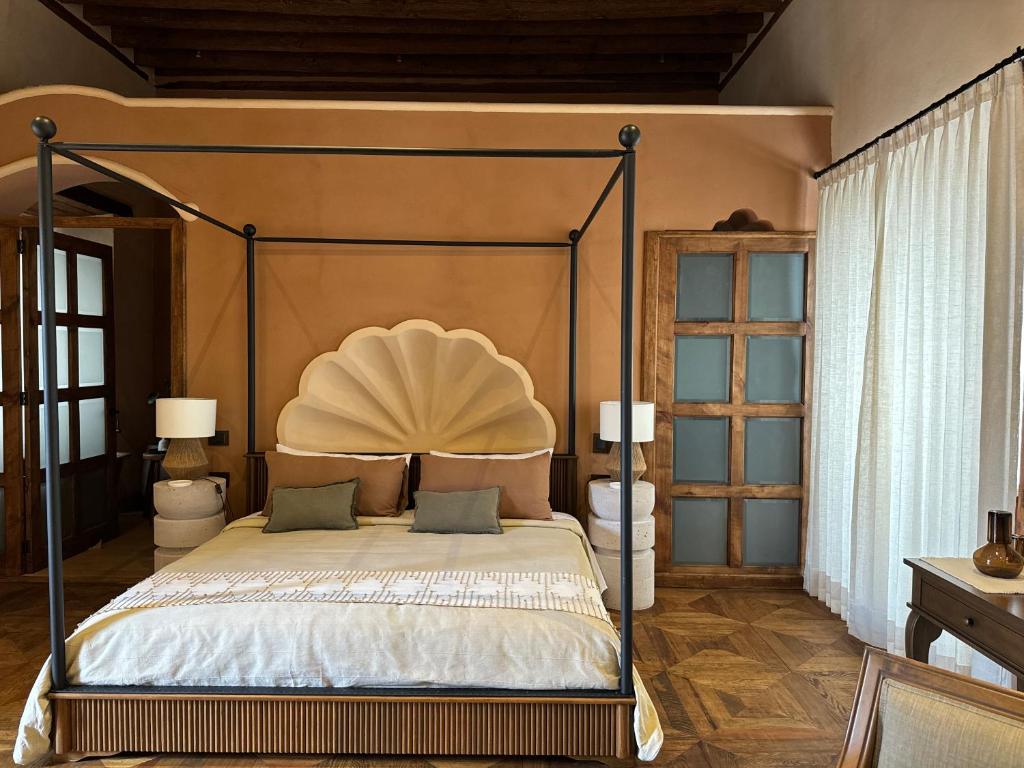a bedroom with a bed with a metal canopy at Hotel Ibarra 14 in Pátzcuaro