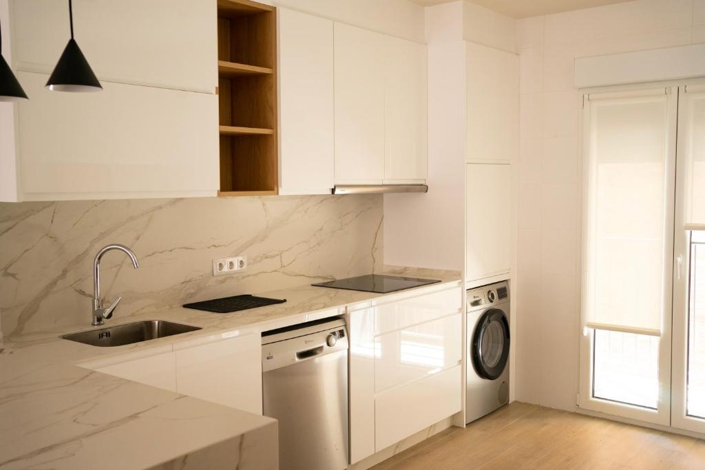a white kitchen with a sink and a dishwasher at Alojamiento NUEVO en el centro de León - Edificio RVM in León