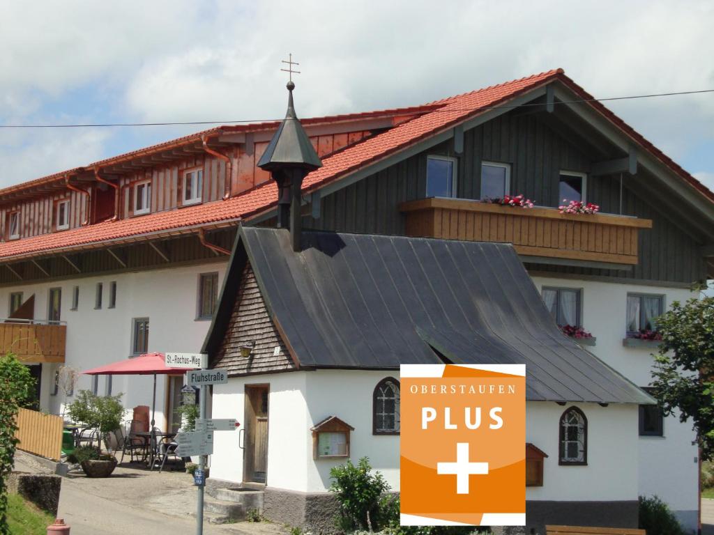 eine Kirche mit einem Pluspunkt davor in der Unterkunft Ferienwohnungen Weixler Schindelberg in Oberstaufen