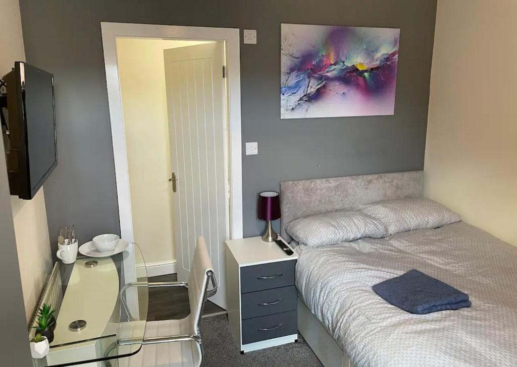 a bedroom with a bed and a desk and a mirror at Ensuite Room, Hotel Standard. Close to Crewe Train Station in Crewe