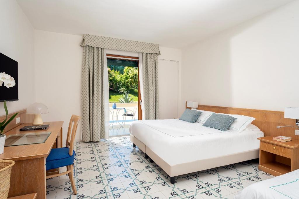 Postel nebo postele na pokoji v ubytování Grand Hotel Vesuvio