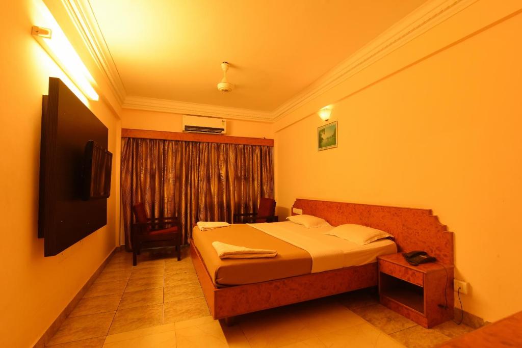 ein Schlafzimmer mit einem Bett in einem Zimmer mit einem Fenster in der Unterkunft Hotel Sri Ram Residency in Udupi