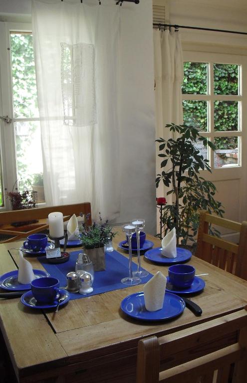 a wooden table with blue plates and napkins on it at Pension Reuss - Hotel garni in Erfurt