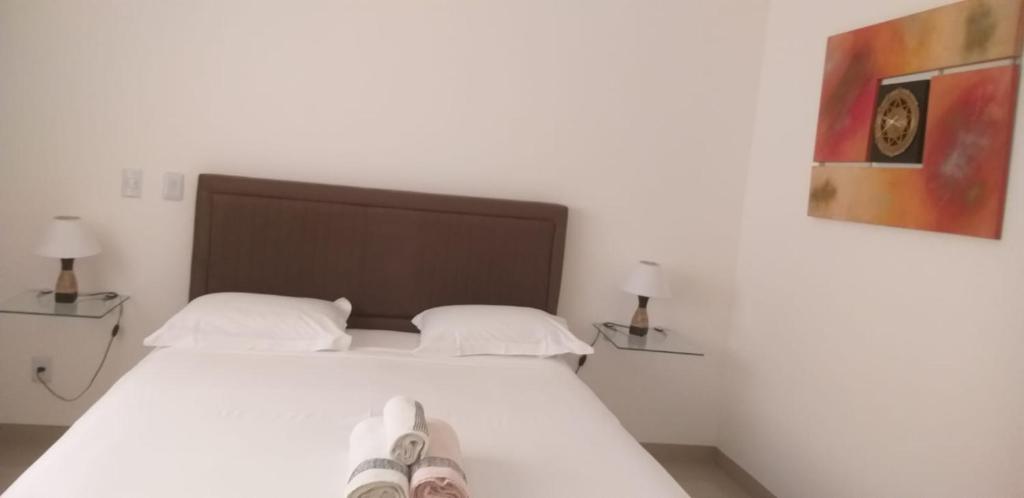 a bedroom with a bed with a pair of shoes on it at Apartamento no centro próximo a Jk in Palmas