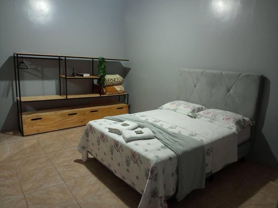 ein Schlafzimmer mit einem Bett und eine Kommode mit einem Spiegel in der Unterkunft Apto Confortável e espaçoso 01 in Cachoeira do Sul