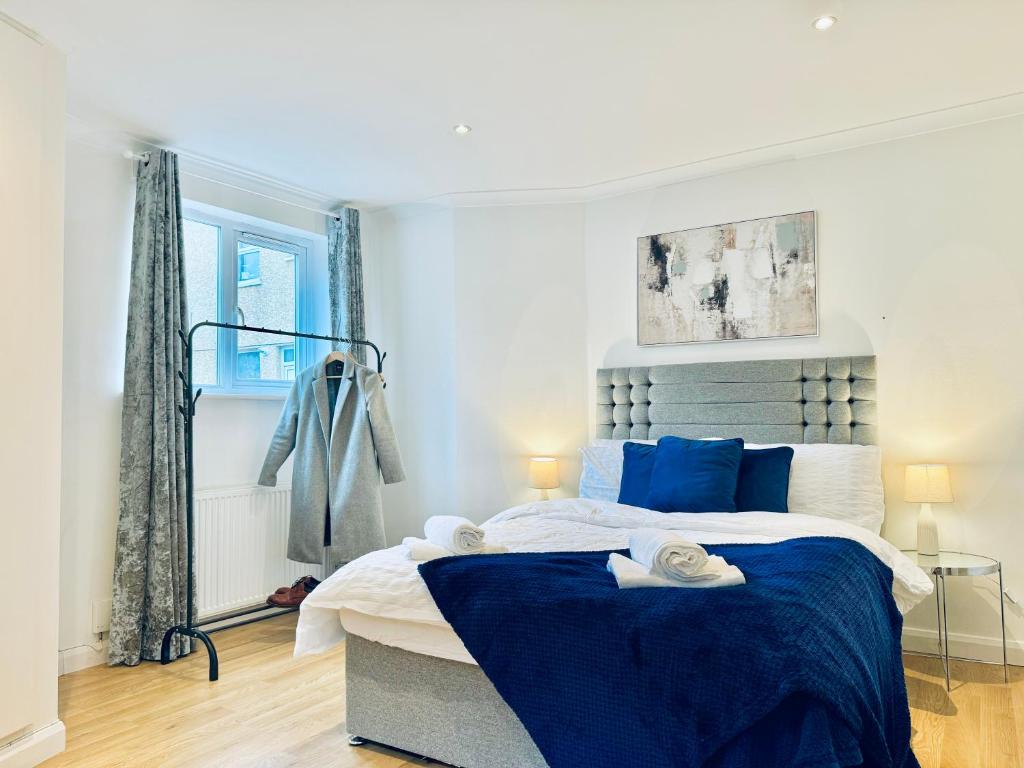 a bedroom with a large bed with blue pillows at Sutton - Ground Floor Flat By The High Street in Sutton