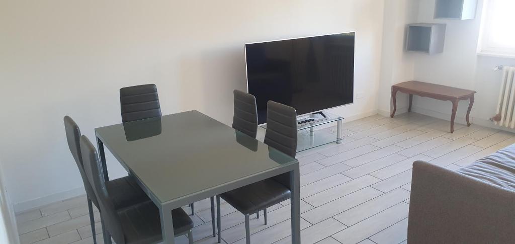 een woonkamer met een tafel en een televisie bij Parkside Heaven Milano Affori in Milaan