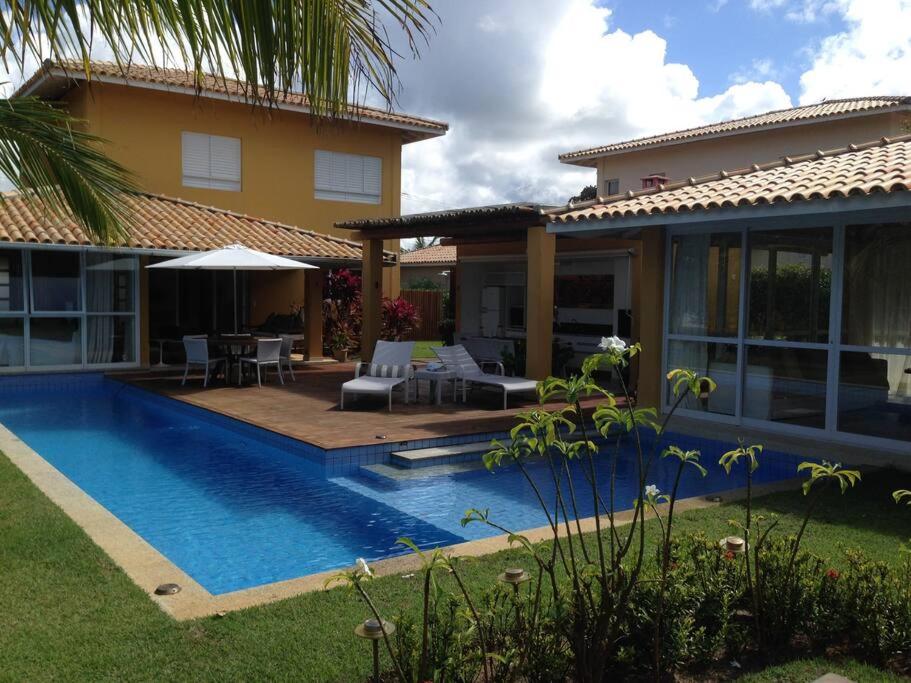 een huis met een zwembad naast een huis bij Quintas de Sauipe - modernes Haus im Condomínio mit Service in Mata de Sao Joao