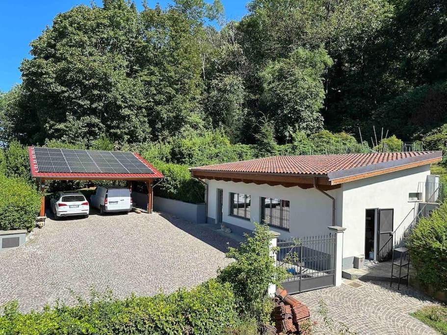 een huis met een zonnedak met twee geparkeerde auto's bij La casa di Anna in Turijn