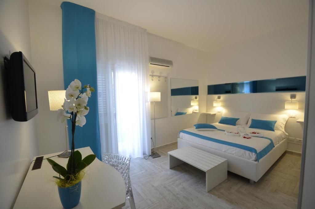 een witte en blauwe slaapkamer met een bed en een tafel bij Di Ma B&B in Porto Cesareo