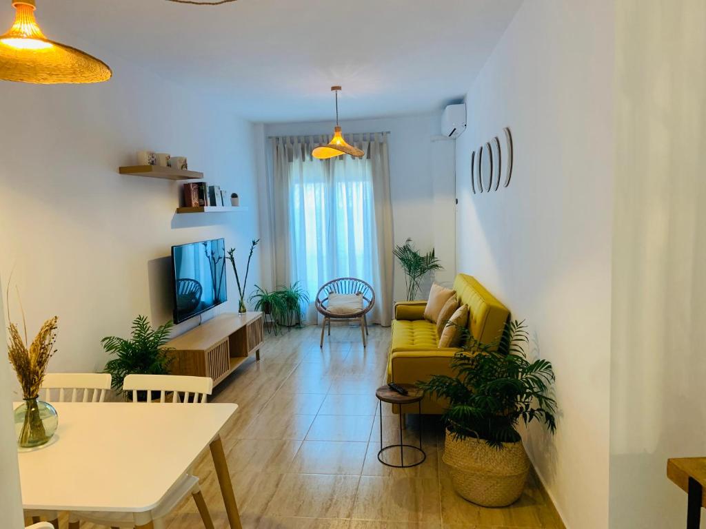 sala de estar con sofá amarillo y mesa en Apartamento Las Minas, en Baeza