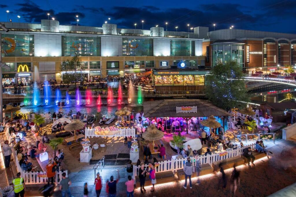 a crowd of people walking around a shopping center at night at Stylish House with parking in Caversham nr Reading, by Sauvignon Stays in Caversham