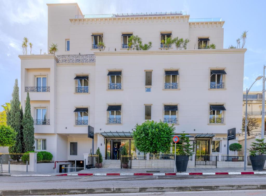 un gran edificio blanco en una calle de la ciudad en Lalla Doudja Hotel en Argel