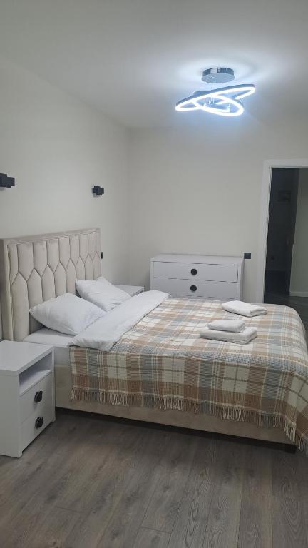 una camera con un grande letto con testiera bianca di Аэропорт Кишинев 24&24 a Chişinău