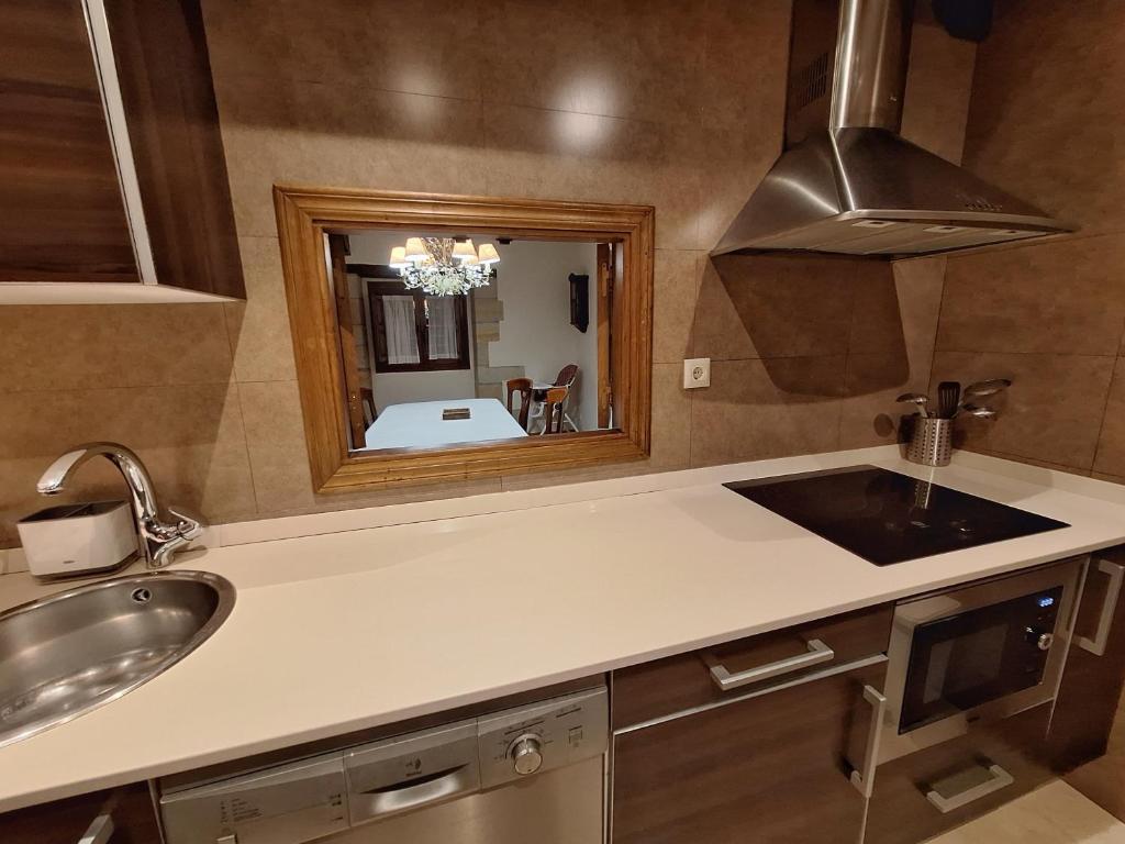 uma cozinha com um lavatório e um espelho em APARTAMENTOS PALACION DE SANTILLANA em Santillana del Mar