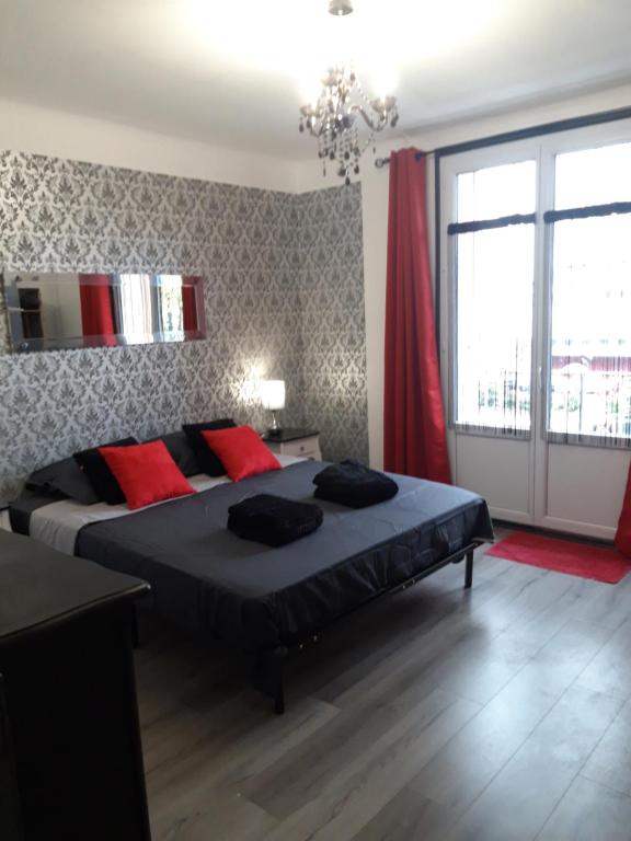 une chambre avec un grand lit avec des oreillers rouges dans l'établissement Verdun 228 Insolite, à Chambéry