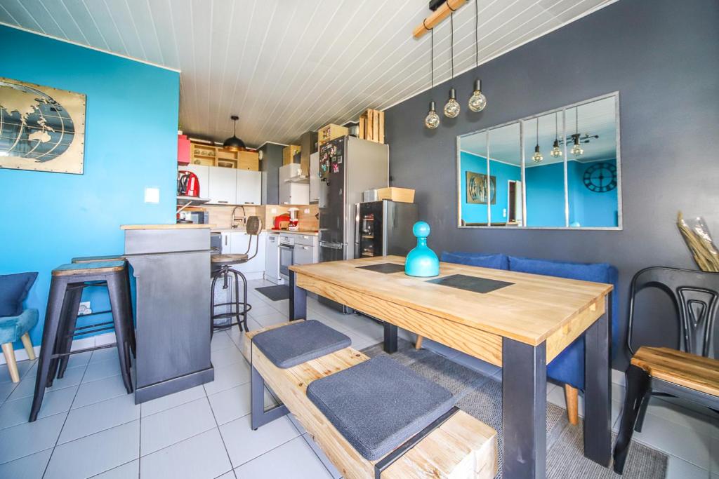 eine Küche und ein Esszimmer mit einem Holztisch in der Unterkunft Grand T2 Montpellier Climatisation Terrasse Proche centre Ville et Plages in Montpellier
